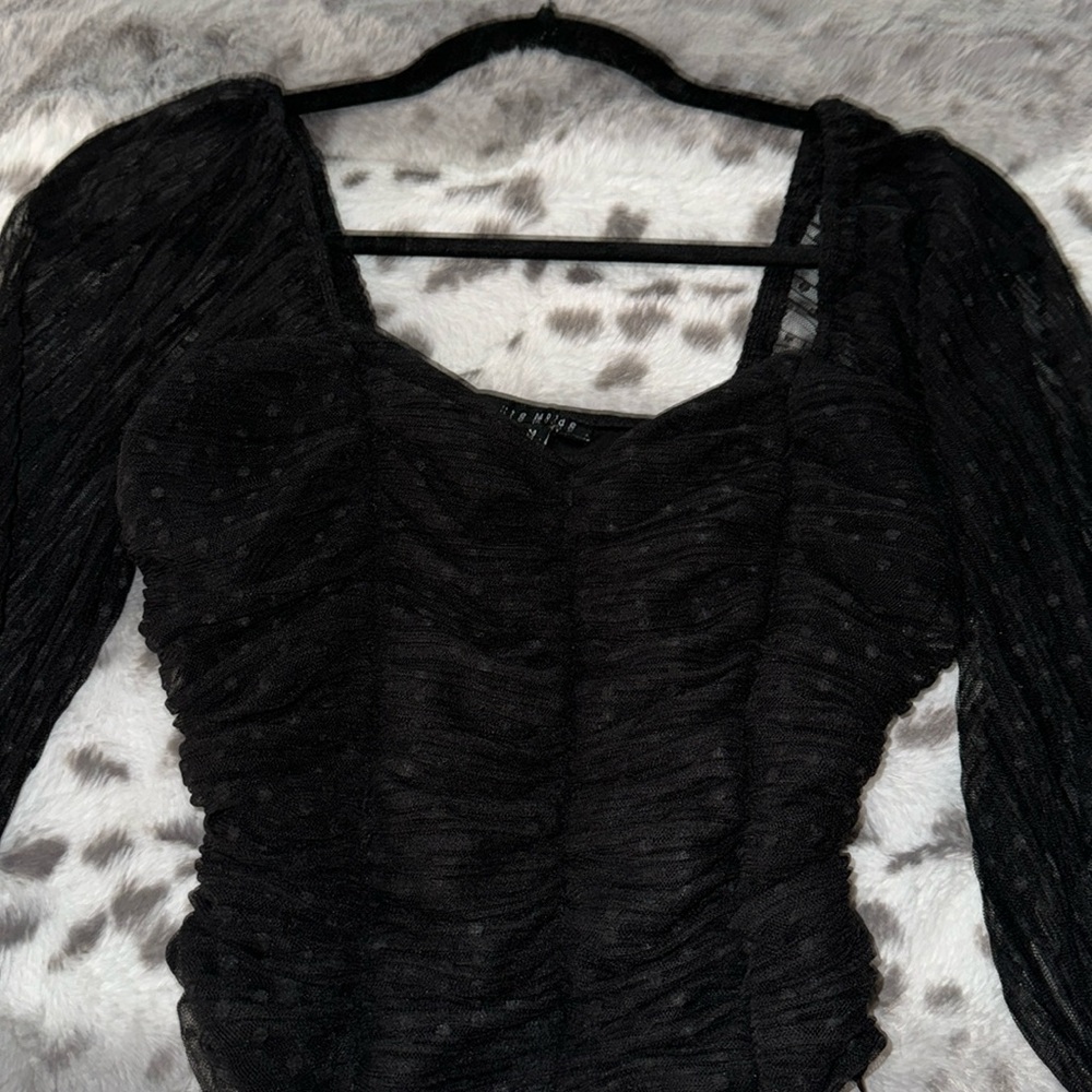 Black long sleeve blouse with puffed sleeves.